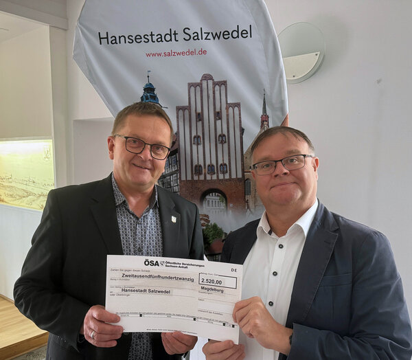 Bild vergr&ouml;&szlig;ern: Bj�rn Hoppe (r.) �berreichte den Scheck an B�rgermeister Olaf Meining